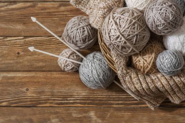 Eski ahşap zeminin arka planında iplik yumakları olan sepet