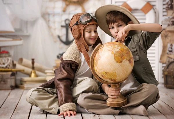 两个男孩 旅行者和飞行员 的画像 他的游戏室里放满了地球仪 — 图库照片