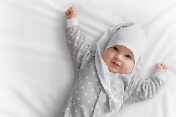 Cute smiling baby in bed after sleep