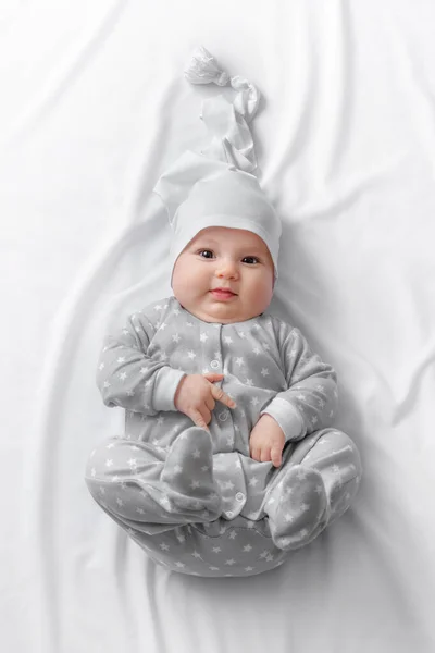 Cute smiling baby in bed after sleep