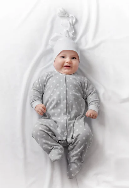 Cute smiling baby in bed after sleep