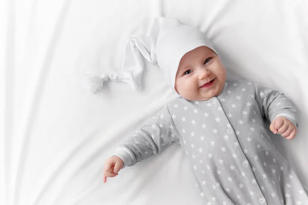 Cute smiling baby in bed after sleep