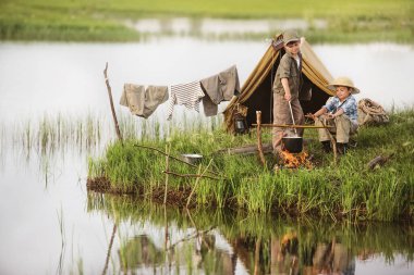 İki çocuk bir yaz akşamı gölün kıyısında kamp kurup ateşi yaktılar.