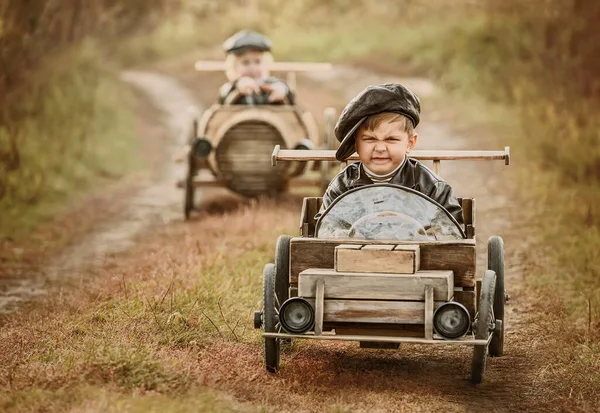 Två Pojkar Ryttare Tävlar Mot Varandra Hemmagjorda Träbilar Landsvägen Retusch — Stockfoto