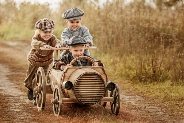 Two Young Children Ride Third Race Car Wooden Barrels Rural — Stock Photo, Image