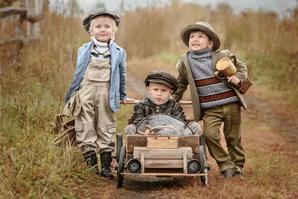 Trzech Małych Chłopców Zawodników Rywalizuje Improwizowanych Drewnianych Samochodach Tle Krajobrazu — Zdjęcie stockowe