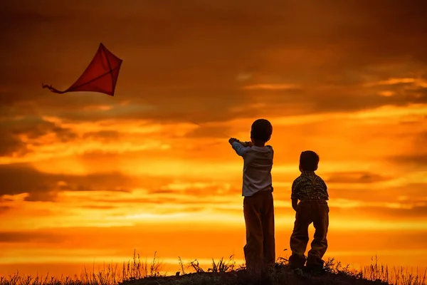 Çocuklar Gün Batımında Sahada Uçurtma Fırlatırlar — Stok fotoğraf