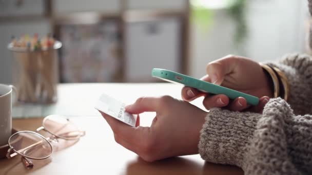 Молодая женщина покупает онлайн с помощью своего телефона — стоковое видео