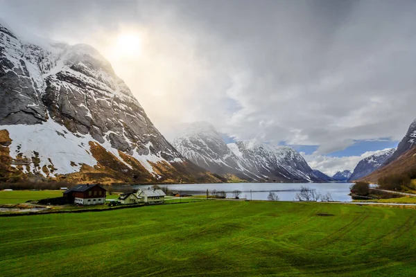 岩の山脈 ノルウェー間の湖の横にある家を解決します — ストック写真