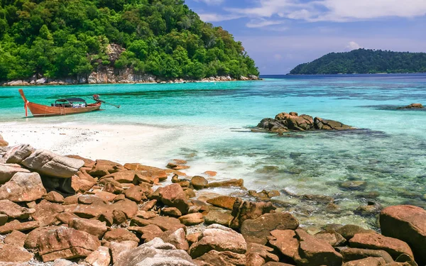 Vackert hav och strand med långsvansbåt på tropisk ö Stockfoto