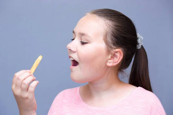 Ragazza Siede Una Panchina Mangia Patate Con Bocca Aperta Foto Stock Royalty Free