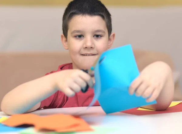 Lindo Chico Sonriente Está Cortando Papel Usando Tijeras Educación Concepto Imágenes de stock libres de derechos