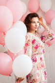 Krásná mladá dívka v šatech s balonky na narozeniny. Portrét roztomilé ženy s vícebarevné bubliny. Roztomilá brunetka ve studiu s maso plněné