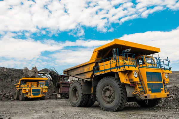 Großer Baggerkipper. Verladen des Gesteins in Kipper. Verladen von Kohle in Karosseriewagen. Produktion nützlicher Mineralien. Bergbau-LKW Bergbaumaschinen, um Kohle aus dem Tagebau als die Kohleproduktion zu transportieren. — Stockfoto