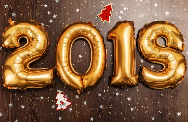 Jasne złota metalicznego balony figury 2018, Boże Narodzenie, nowy rok balon z brokat gwiazd na tle ciemnego drewna tabela — Zdjęcie stockowe