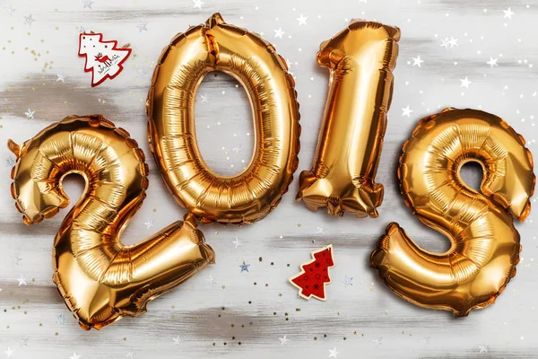 Jasne złota metalicznego balony figury 2018, Boże Narodzenie, nowy rok balon z brokat gwiazd na tle biały stół z drewna — Zdjęcie stockowe