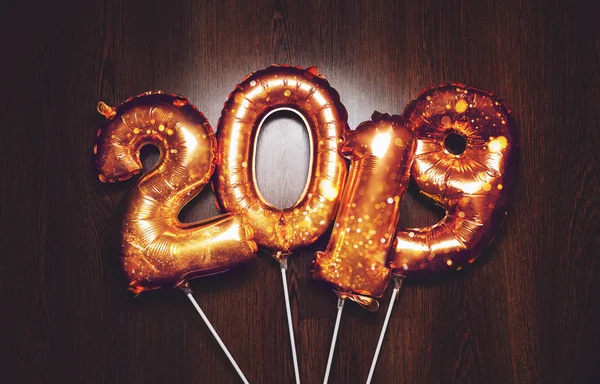 Nowy rok 2019 Bright złota metalicznego balony figury, Boże Narodzenie, nowy rok balon z brokatem gwiazdki na ciemnym tle drewna — Zdjęcie stockowe