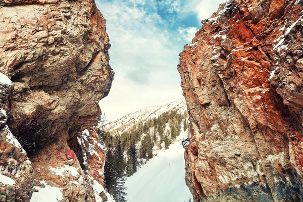 Bellissimo paesaggio invernale in montagna. passaggio innevato nella gola. Strada invernale tra le rocce. Alba nevosa in montagna — Foto Stock