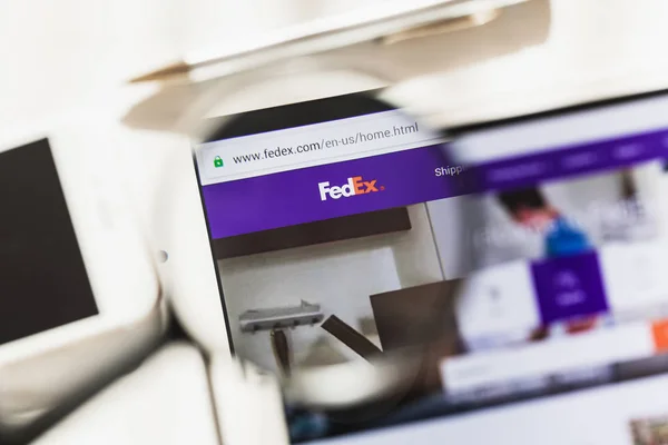 Washington, D.C., - 27 februarie 2019: Pagina principală oficială a site-ului FedEx Express sub lupă. Concept FedEx Express logo vizibil pe smartphone, ecran tabletă , — Fotografie, imagine de stoc