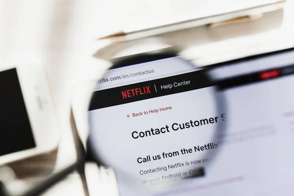 Los Angeles, California, USA - 6 March 2019: Netflix, NFLX official website homepage under magnifying glass. Concept Netflix Inc., logo visible on smartphone, tablet screen, — Stock Photo, Image