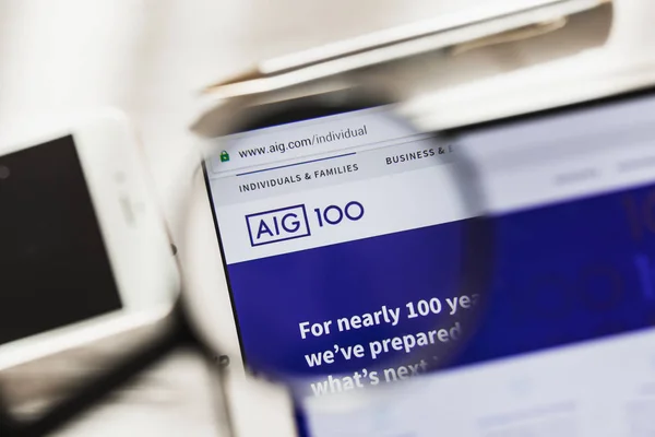 New York, Amerika Birleşik Devletleri - 6 Mart 2019: American International Group, AIG resmi web sitesi ana Büyüteç altında. Kavram American International Group, AIG logo üzerinde akıllı telefon, tablet ekran görünür — Stok fotoğraf