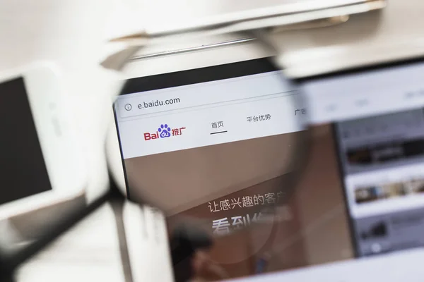 China, Beijing - 7 March 2019: Baidu, Search system official website homepage under magnifying glass. Concept Baidu, Search system logo visible on smartphone, tablet screen, — Stock Photo, Image