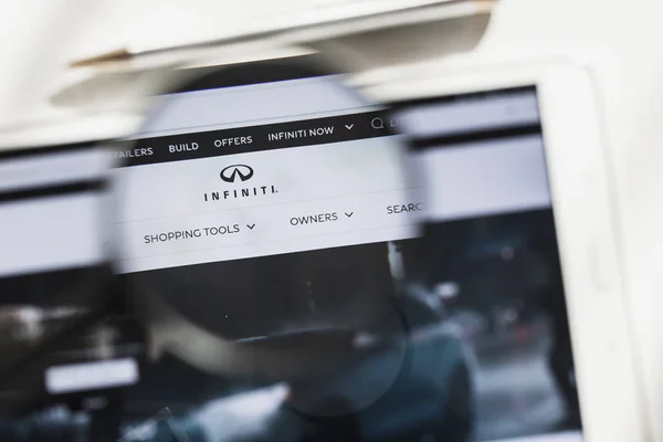 Nishi-ku, Yokohama, Japón - 14 de marzo de 2019: Infiniti Motor Company, coche, página web oficial bajo lupa. Concepto Infiniti Motor Company, logotipo del coche visible en el teléfono inteligente, pantalla de la tableta , — Foto de Stock