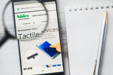 Los Angeles, Kaliforniya, ABD-3 Nisan 2019: Nidec Corporation resmi web sitesi ana sayfa büyüteç altında. Konsept Nidec elektronik bileşenler logosu akıllı telefonda görünür, tablet ekran