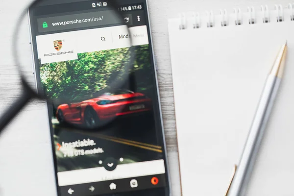 Лос-Анджелес, Калифорния, США - 3 апреля 2019 года: официальный сайт Porsche AG под лупой. Porsche, логотип автомобиля виден на смартфоне, экран планшета — стоковое фото