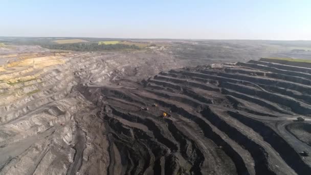 Panorama luchtfoto schot open put mijn kolenmijn bouw, dumpers, delfstoffen extractieve industrie strippen werk. Grote gele mijnbouw trucks. Bekijk van drone bij open cast Mining met veel machine trucks — Stockvideo