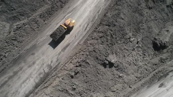 Panorama vista aérea tiro mina a céu aberto mineração de carvão, dumpers, pedreira indústria extrativa descascando trabalho. Grandes caminhões mineiros amarelos. Vista de drone na mineração a céu aberto com lotes de caminhões de máquinas — Vídeo de Stock