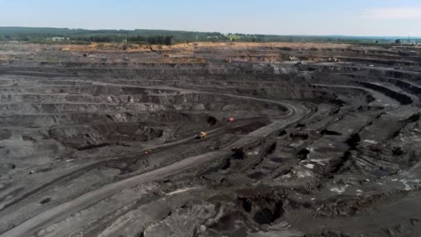 Panorama vista aérea tiro mina a céu aberto mineração de carvão, dumpers, pedreira indústria extrativa descascando trabalho. Grandes caminhões mineiros amarelos. Vista de drone na mineração a céu aberto com lotes de caminhões de máquinas — Vídeo de Stock