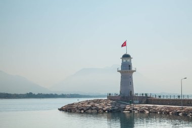 Deniz feneri. Alanya'da deniz feneri, Antalya ilçesi, Türkiye. Popüler turistik yer. Şafak vakti Alanya liman kasabasında deniz feneri ile manzara.