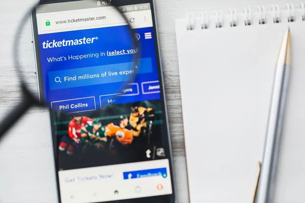 Los Angeles, California, USA - 9 June 2019: Ticketmaster Entertainment official website homepage under magnifying glass. Concept Ticketmaster.com logo visible on smartphone, tablet screen — Stock Photo, Image