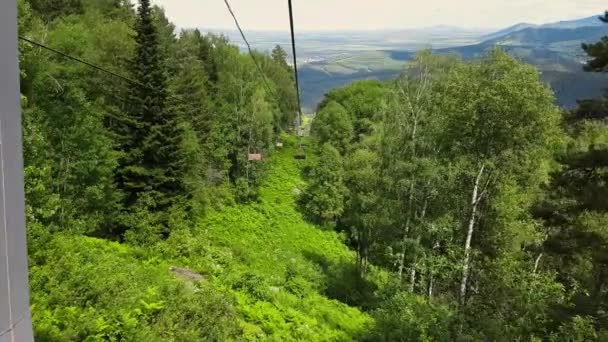 Panorama antenn utsikt på ropeway. Stollift i skogen. Förflyttning på linbanan på sommaren genom skogen. Flytta bergbanan till berget — Stockvideo