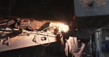 Kaynakçı işte. Kaynakçı büyük kamyonları tamir eder. İş yerinde kaynakçıyavaş çekim. Adam üretimde kaynak çalışmaları yürütmektedir