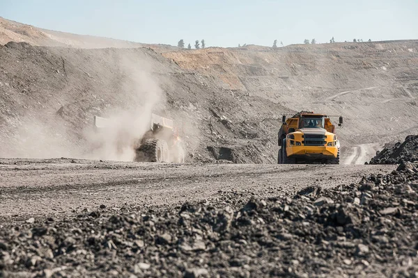 大きな採石場のダンプトラック。岩をダンパに積み込みます。石炭をトラックに積み込む。有用な鉱物を生産する。坑内掘削機の作業から石炭を輸送する鉱山機械 — ストック写真