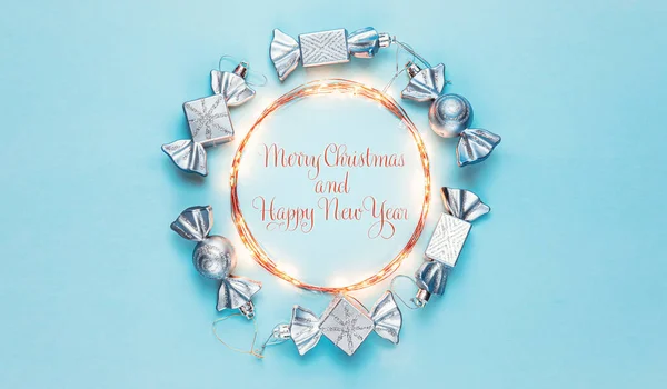 2021年。メリークリスマスとハッピーホリデーグリーティングカード。クリスマスの構図。パステルブルーの背景に銀の装飾。冬、新年のコンセプト。フラットレイアウト、トップビュー、コピースペース — ストック写真