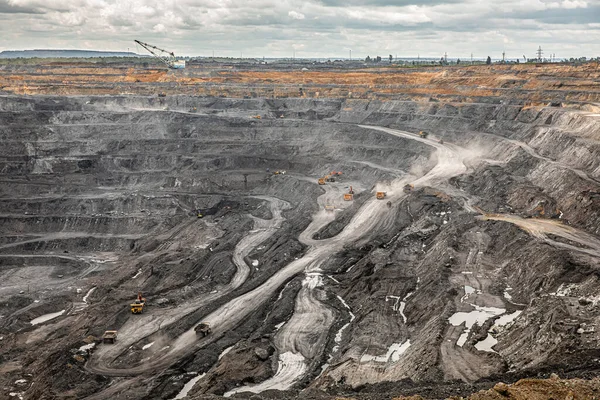 Panoramic aerial view of coal mine. Open pit mine industry, big yellow mining truck for coal quarry. Open coal mining anthracite mining. Pit on coal mining by open way. Rock loading in trucks