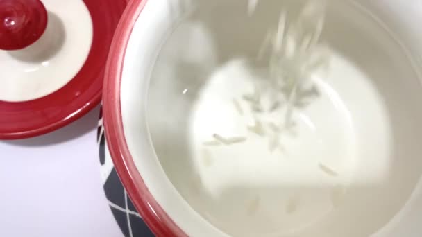 Сырой Белый Рис Басмати Наливают Керамический Контейнер Изолированном Белом Фоне — стоковое видео