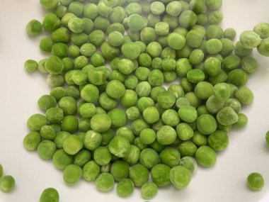 Güzel organik taze bezelyeler, izole edilmiş beyaz arka planda küçük kabarcıklar ile suya batırılmış.