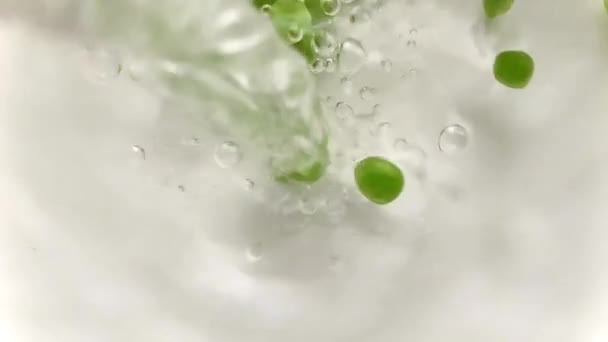水泡中飘浮的美丽的有机新鲜豌豆是由不断落下来的豌豆流入清澈的水中而产生的 — 图库视频影像