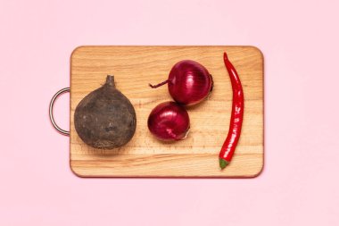 Pancar yakınındaki iki taze menekşe yay ve bir kırmızı biber biber