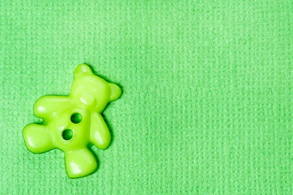 質感のある緑の背景にクマの形をした緑のボタン グリーティングカードのコンセプト — ストック写真