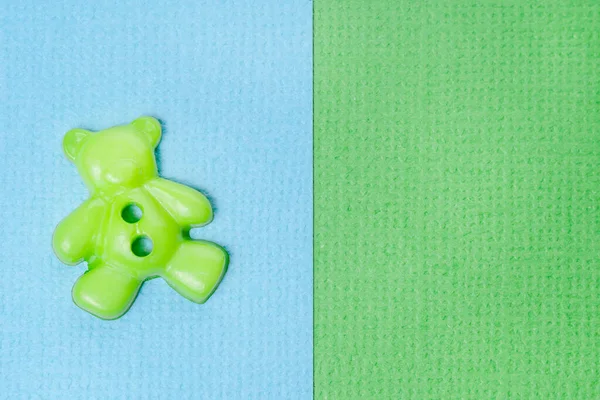 質感のある青と緑の背景にクマの形をした緑色のボタン グリーティングカードのコンセプト — ストック写真