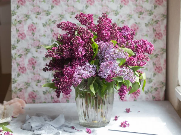 Bouquet of violet lilac in a vase. Still life with blooming branches of lilac in vases. Free style photo.