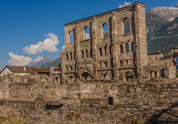 Aosta, İtalya-17 Haziran 2019: Aosta'nın Roma teather'i, 22 metre yüksekliğinde kemerler ve pencerelerle delinmiş bir cephesi ile Roma dönemine ait.
