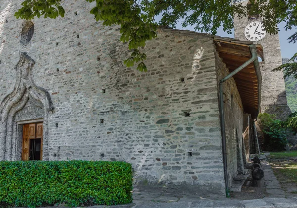 Arnad,İtalya/Aosta Vadisi-4 Haziran 2019.1500'lerin Saint Martin'in taş kilisesi, merkezi kapıyı çevreleyen tüf kemerli, iki bükülmüş üç gövdeyi betimleyen