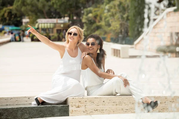 İki çok ırklı kız arkadaşım tatilde eğleniyor. Sarışın güzel kadın ile Afrikalı-Amerikalı genç bayan. Gülümseyerek, Monako birlikte vakit kızlar.