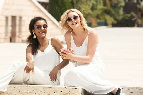 İki çok ırklı kız arkadaşım tatilde eğleniyor. Sarışın güzel kadın ile Afrikalı-Amerikalı genç bayan. Gülümseyerek, Monako birlikte vakit kızlar.